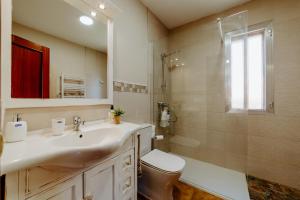 a bathroom with a sink and a toilet and a shower at Casa Raíces de PO in Lapoblación