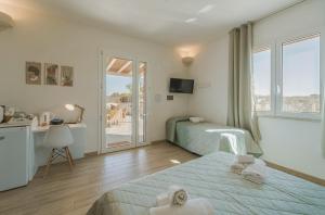 a hotel room with two beds and a balcony at Cave Garden rooms in Favignana