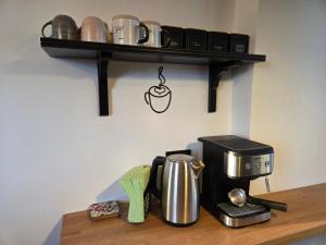a coffee maker on a shelf with a coffee pot at Still Garden House in Bezden