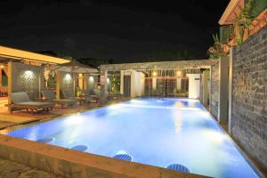 a swimming pool in a backyard at night at Sakun House in Siem Reap