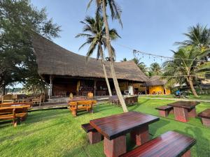a group of picnic tables in front of a building at Phoenix Room in Ban Tha Samet (1)