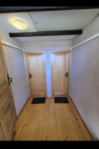 an empty room with two doors and wooden floors at Sobe na vinskoj cesti Zmajevac in Zmajevac