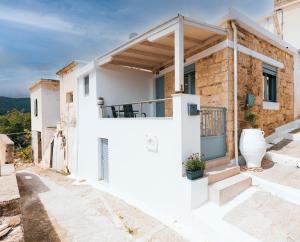 a white house with a balcony and stairs at Liopetro in Sitia