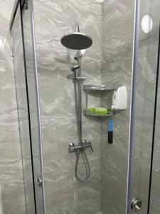 a shower with a glass door with a shower head at Bujtina cela in Berat +66 photos
