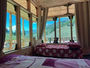 a bedroom with two beds and a view of a mountain at Peak Paradise Resort in Taobat