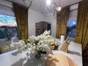 a table with a vase of flowers and fruit on it at Aluxhaus in Heidenau
