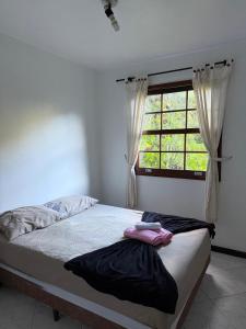 a bed in a room with a window at Sitio vale das araucarias in Araras Petropolis