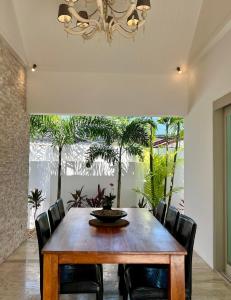 a dining room with a wooden table and chairs at Baan Tai Tara 4, Private Pool Villa by Ban Tai Beach in Ban Tai