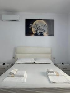 a white bed with two white towels on it at Bujtina cela in Berat