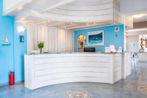 a lobby with a white counter in a room with blue walls at Blue Sea Hotel in Amoopi