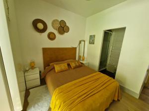 a bedroom with a bed with a yellow blanket at Le refuge des deux âmes in Alby