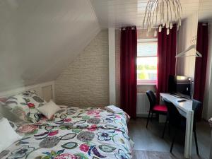 a bedroom with a bed and a desk and a computer at Aluxhaus in Heidenau