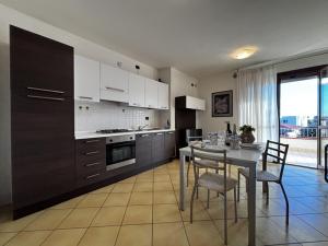 a kitchen with a table and chairs and a kitchen with a window at Residence Mairen a pochi passi dal mare in Rosolina Mare