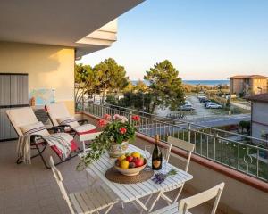 a balcony with a table with a bowl of fruit at Residence Mairen a pochi passi dal mare in Rosolina Mare