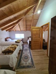 a room with two beds and a rug at Guest House Korabi in Ceren