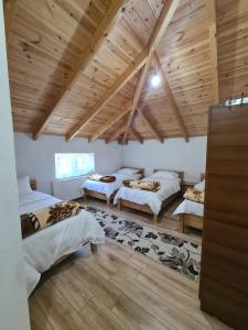 a room with three beds and a wooden ceiling at Guest House Korabi in Ceren +52 photos