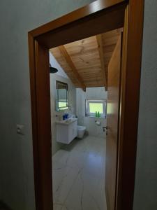 an open door to a bathroom with a toilet and sink at Guest House Korabi in Ceren