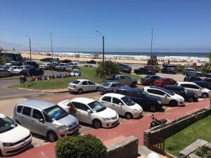 un montón de coches estacionados en un estacionamiento cerca de la playa en Apartamento Frente a Playa los Dedos, en Punta del Este