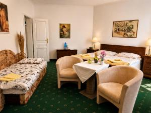 a hotel room with two beds and a table and chairs at Kristoff Plaza Trencianske Teplice in Trenčín +58 photos