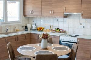 a kitchen with a table with a vase of flowers on it at Aura 2 Apartment in Vathý