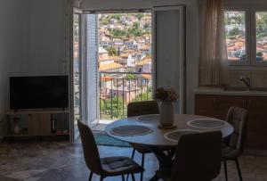 a living room with a table and chairs and a television at Aura 2 Apartment in Vathý +18 photos