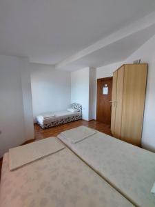 an empty room with two beds and a cabinet at Villa Chaloski in Peštani +15 photos