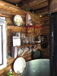 a kitchen with wooden walls and a counter with dishes at East cross forest log cabin in Burketon Station