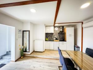 a kitchen and dining room with a wooden table at Apartment Gacka in Otočac