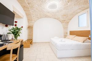 a bedroom with a bed and a desk with a computer at Palazzo Kapece in Monopoli