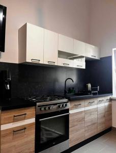 a kitchen with white cabinets and a stove top oven at Apartament Bydlino in Bydlino