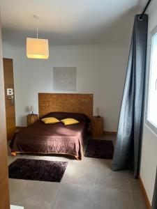 a bedroom with a bed in a room with rugs at Mountain and Sea in Ribeira Grande