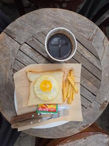 a table with an egg and french fries and a cup of coffee at BROMO B&B in Bromo
