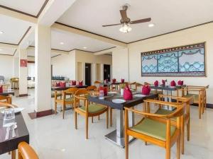 a restaurant with tables and chairs and a ceiling at Lillium Hotel & Spa in Kalimpong