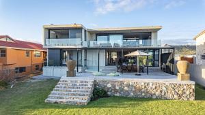 a modern house with a stone retaining wall at Mi Amor Beach House in Sedgefield