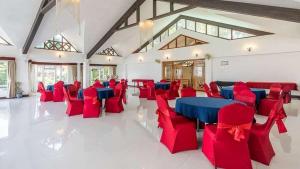a large room with red chairs and a blue table at Lillium Hotel & Spa in Kalimpong