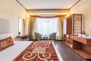 a hotel room with a bed and a table and chairs at Lillium Hotel & Spa in Kalimpong +17 photos