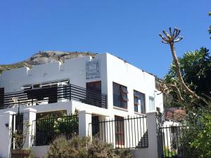 a white building with a mountain in the background at Paarl Mountain Lodge in Paarl