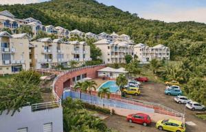 a group of apartment buildings with cars parked in a parking lot at Studio SUCRIER TARTANE in La Trinité