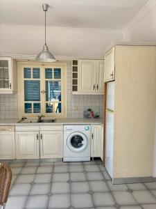a kitchen with a washer and dryer in it at Sylvia Studios in Agia Marina Aegina