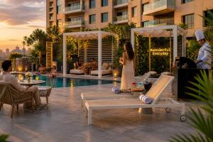 a woman in a white dress standing next to a pool at Millennium Central Downtown - Dubai in Dubai