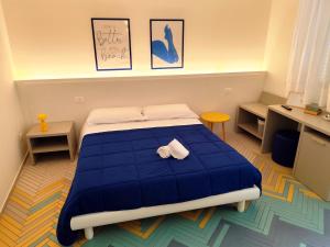 a bedroom with a blue bed with two towels on it at Cefalhub in Cefalù