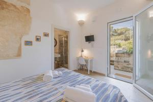 a bedroom with a king sized bed and a window at Cave Garden rooms in Favignana