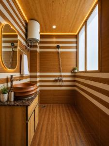 a bathroom with a sink and a wooden wall at APine Cottages - Two Bedroom, One Luxury Getaway in Nārkanda