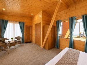 a bedroom with a bed and a table and chairs at APine Cottages - Two Bedroom, One Luxury Getaway in Nārkanda