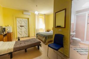 a bedroom with a bed and a chair and a mirror at Casa Vacanza Capozzoli in Albanella +73 photos