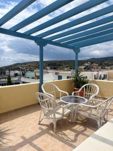 a patio with chairs and a table on a balcony at Sylvia Studios in Agia Marina Aegina