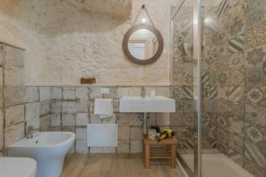 a bathroom with a sink and a mirror at Cave Garden rooms in Favignana +23 photos