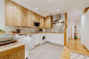 a kitchen with white appliances and wooden cabinets at Alojamiento en pleno centro con WIFI y Aire Acondicionado in Logroño