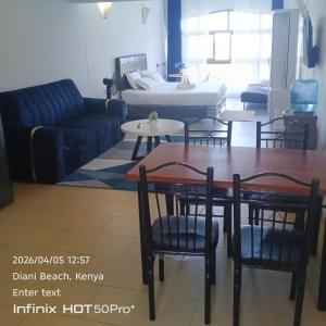 a living room with a couch and a table and chairs at Diani dreams Villa in Ukunda