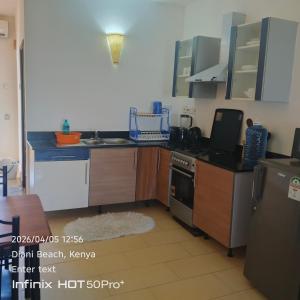 a kitchen with a sink and a stove at Diani dreams Villa in Ukunda